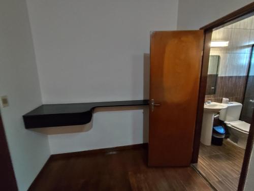 bagno con porta in legno e lavandino di CEDE Inn Hotel a Encarnación