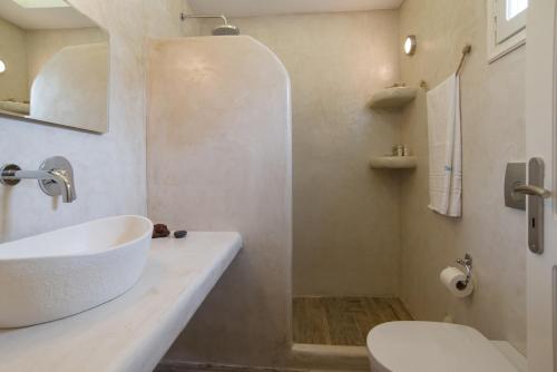 a white bathroom with a sink and a toilet at Villa Galinia in Akrotiri