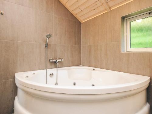 a white bath tub in a bathroom with a window at 6 person holiday home in Asaa-By Traum in Aså
