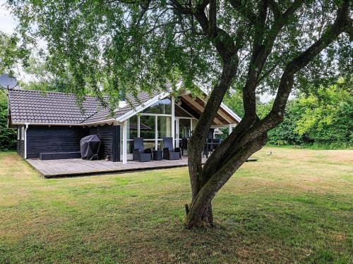 a house with a tree in the yard at 6 person holiday home in Asaa-By Traum in Aså