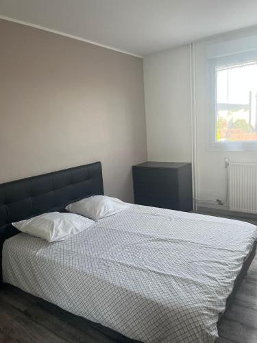 une chambre avec un lit avec des draps blancs et une fenêtre dans l'établissement T4 3chambres spacieux tout équipé 6 personnes, à Besançon