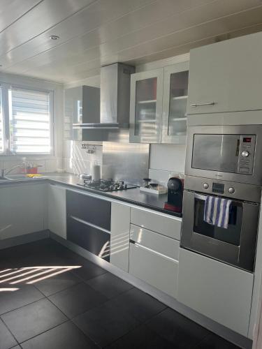 une cuisine avec une cuisinière et un micro-ondes dans l'établissement T4 3chambres spacieux tout équipé 6 personnes, à Besançon