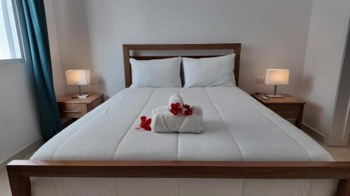 Un dormitorio con una cama con dos flores rojas. en 2BR Beach Apartment With Washer, en Las Terrenas