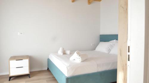 a bedroom with a blue and white bed and a nightstand at Kompleksi Turistik ARMANDO in Tale