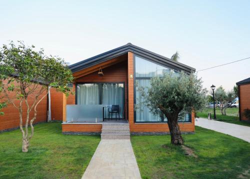 a house with glass doors and a lawn at Kompleksi Turistik ARMANDO in Tale