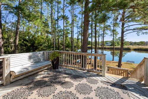 a deck with a view of a lake and trees at Sound Choice In Manteo in Manteo