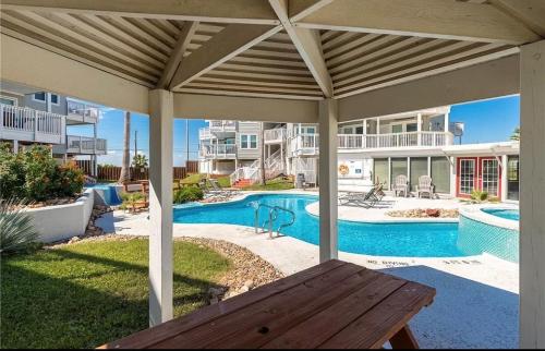 a patio with a wooden table and a swimming pool at Jacks Spot MIBC 116 in Mustang Beach