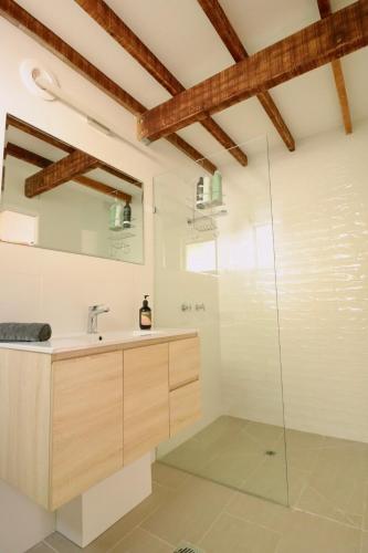 a bathroom with a sink and a glass shower at Maleny-Montville Cottages #1 - 2 bed ocean views in Balmoral Ridge