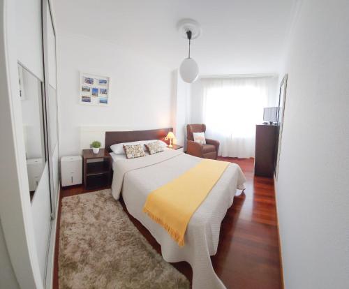 a bedroom with a bed with a yellow blanket at Piso Centro y Playa in Cangas de Morrazo