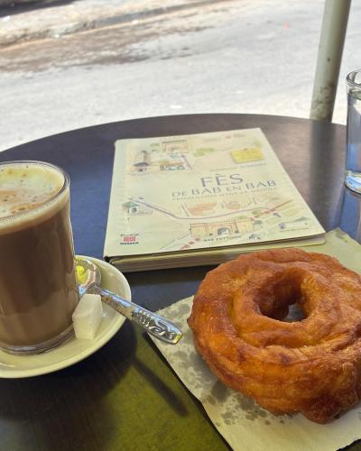 a donut and a cup of coffee on a table at Riad Serendipity in Fès