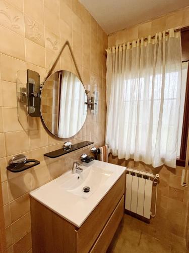 a bathroom with a sink and a mirror at Casa María - 3km del Camino in Santa Eulalia