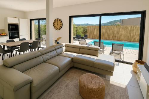 - un salon avec un canapé, une table et une piscine dans l'établissement Villa Moderne de Standing avec Piscine Privée à 400m de la Plage - 4 Chambres, à Conca