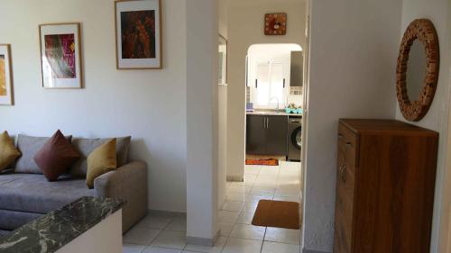 a living room with a couch and a kitchen at Appartement Sabah A Essaouira in Ghazoua