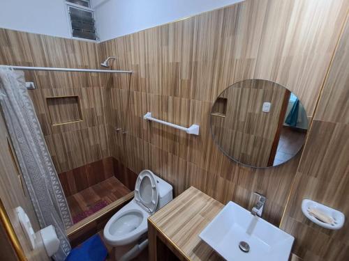 タラポトにあるResidencial Lago Verdeのトイレ、洗面台、鏡を備えたバスルーム
