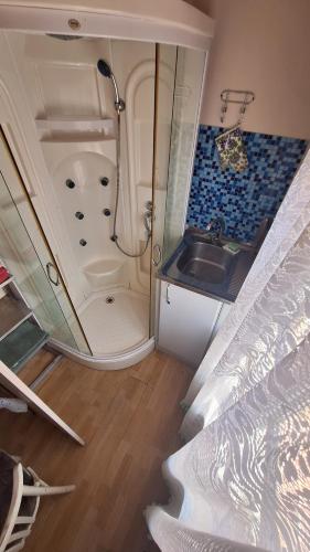 a small bathroom with a sink and a shower at Apartments Londa in Jūrmala
