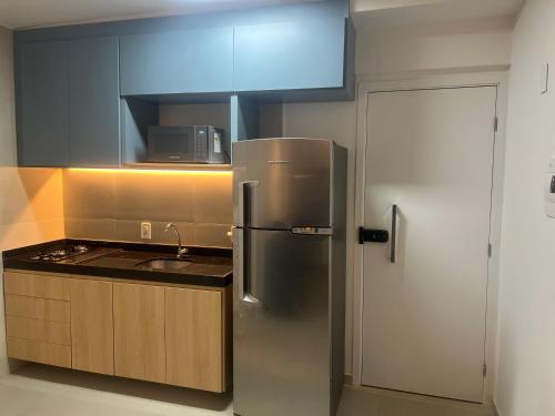 a kitchen with a stainless steel refrigerator and a sink at Tamandaré Refúgio Luxuoso com Piscina Infinita e Mar Azul in Tamandaré
