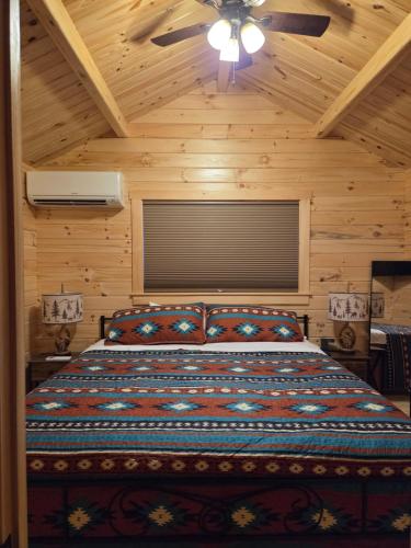 a bedroom with a bed with a ceiling fan at Flint Rock Cabins - The Arrow in Lonsdale