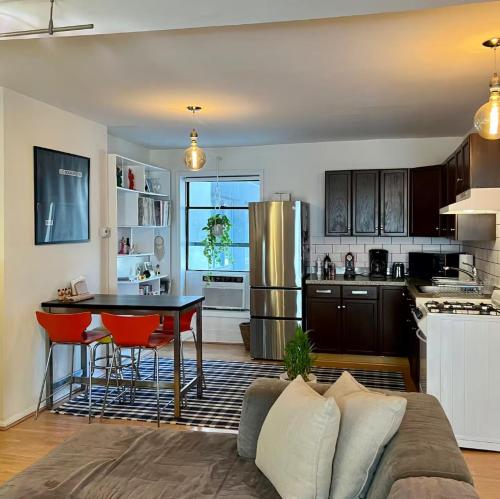 Una cocina con un sofá y una mesa en una habitación. en Chelsea Gem Modern 2BR Apt Prime 23rd & 7th Spot, en Nueva York