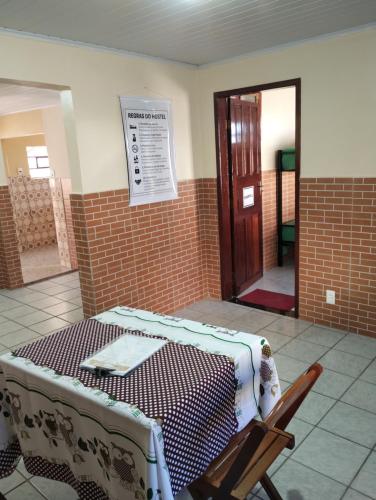 a room with a bed with a table and a door at Hostel da Ladeira in Ouro Preto