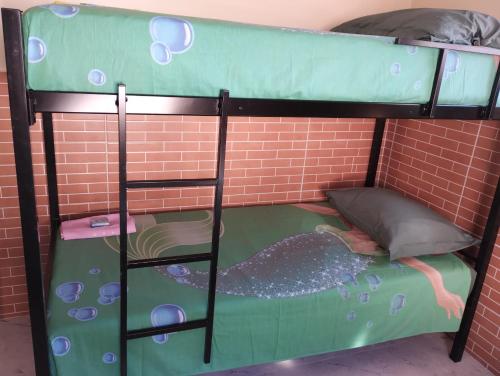 a bunk bed in front of a brick wall at Hostel da Ladeira in Ouro Preto