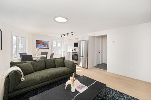 a living room with a green couch and a table at MTL Central Stay Apartments in Montréal