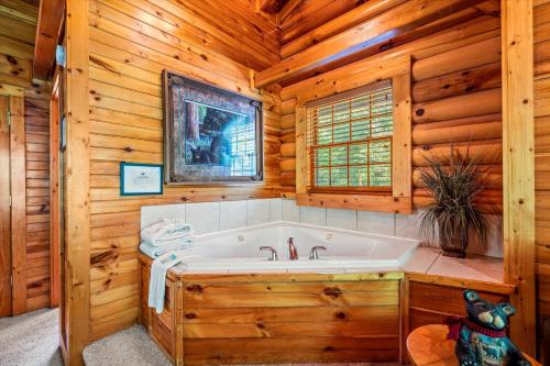 ein Badezimmer mit Badewanne in einer Blockhütte in der Unterkunft The Fontana in Gatlinburg