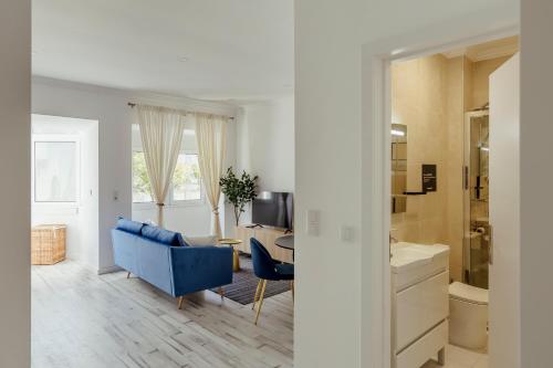 a living room with a blue couch and a desk at Amadora Flat 4 in Amadora