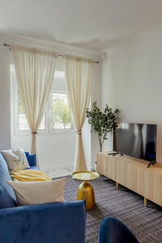 a living room with a blue couch and a tv at Amadora Flat 4 in Amadora