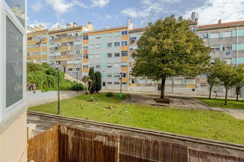 a view from the balcony of a building with a tree at Amadora Flat 4 in Amadora