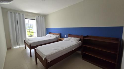 a bedroom with two beds and a blue wall at Refúgio do Atalaia in Salinópolis