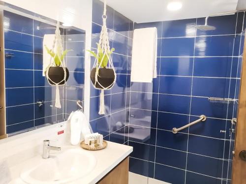 a blue tiled bathroom with a sink and potted plants at Casa Bixa Hotel Boutique by HMC - Mayores de 12 años - in Santa Fe de Antioquia