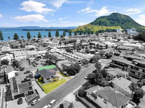 an aerial view of a city with a mountain at Your Downtown Mount Maunganui Escape Awaits! in Mount Maunganui