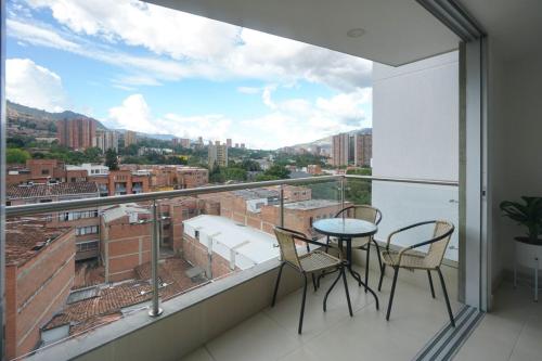 a balcony with a table and chairs and a view at Luxury air conditioning near laureles in Medellín