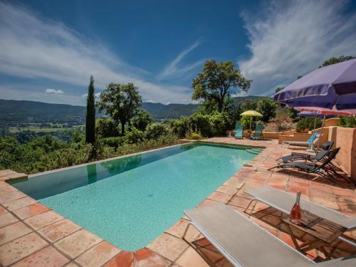 - une piscine extérieure avec des chaises et un parasol dans l'établissement Entre les Vignes, à Emponse