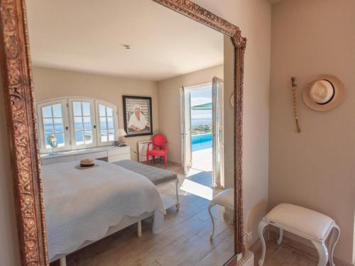 a mirror in a bedroom with a bed and a pool at Lessix 8 in Saint-Peïre-sur-Mer