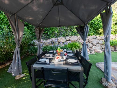 a black tent with a table in a garden at Le Rayol in Bagnols-en-Forêt