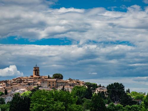 a town on top of a hill under a cloudy sky at Bastide St John in Séguret