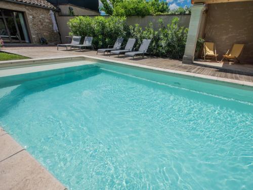 a swimming pool with blue water in a yard at Bastide St John in Séguret