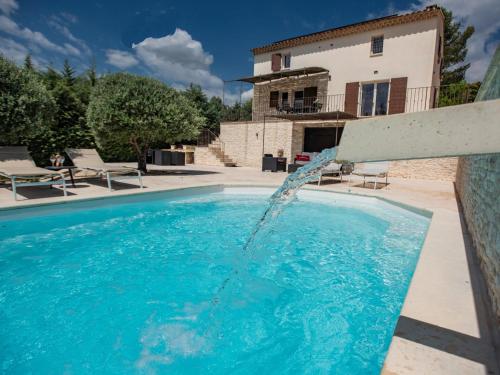 une piscine avec une fontaine en face d'une maison dans l'établissement Le Mistral, à Apt