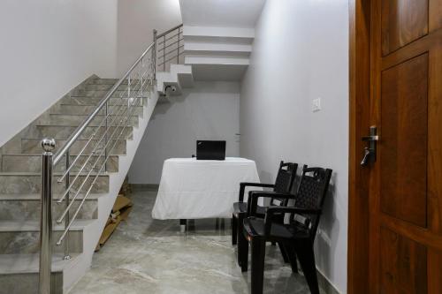 a staircase with a table with a laptop on it at Hotel O Al Ameen Residency in Kannur