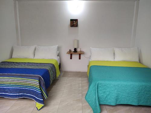 two beds sitting next to each other in a room at casa blanca in Restrepo