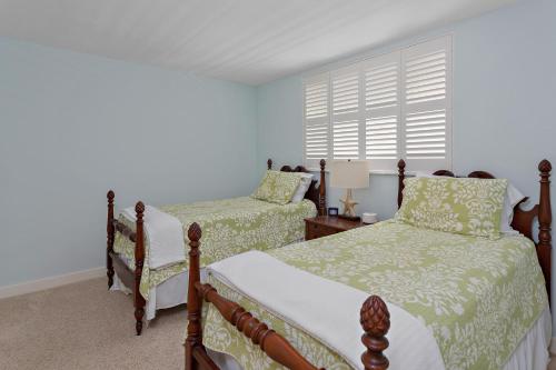 Un dormitorio con dos camas y una ventana. en North Breakers #201, en Saint Simons Island