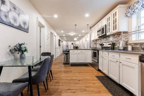 a kitchen with white cabinets and a table and chairs at Modern & Stylish 1-BR Condo near Downtown in Boston