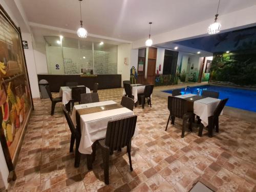 ein Restaurant mit Tischen und Stühlen und einem Pool in der Unterkunft Residencial Lago Verde in Tarapoto