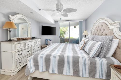 Un dormitorio con una cama, una cómoda y un televisor. en North Breakers #200, en Saint Simons Island