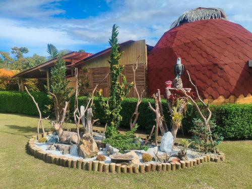 a garden with rocks and a building in the background at Glamping Cabañas Sharmont in Guarne