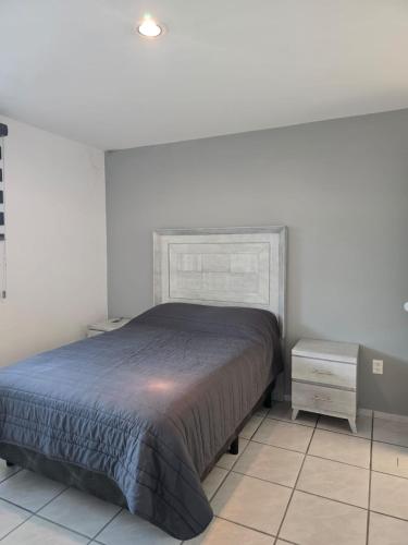 a bedroom with a bed and a night stand at Casa las palmas in Morelia
