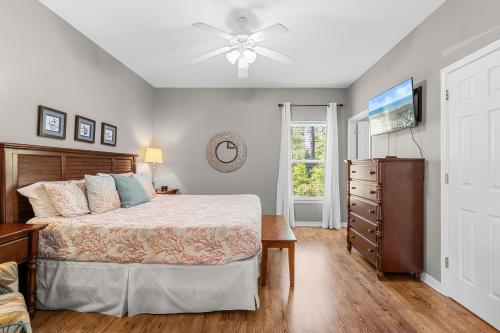 a bedroom with a bed and a ceiling fan at Paradise Found Gulf Shores Beach Pools Dogs in Gulf Shores