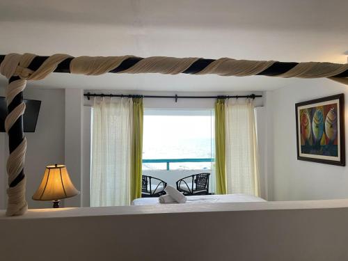 a bedroom with a bed with a view of the ocean at Mango & Apartments in Tumbes