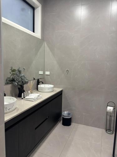 a bathroom with two sinks and a large mirror at Urban Pause - Doreen in Doreen